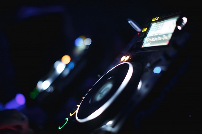 DJ mixing console with glowing lights at night