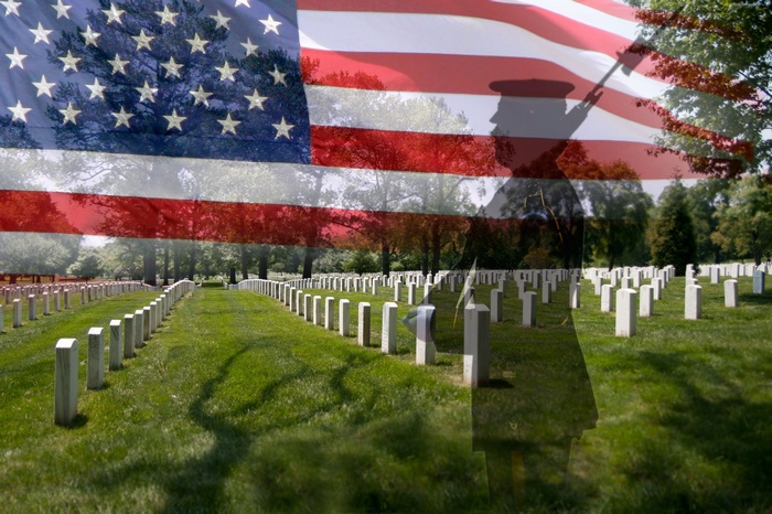 American flag over graves and soldier silhouette