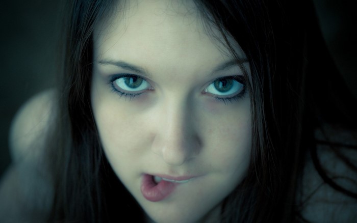 Close up portrait of a young woman biting her lip