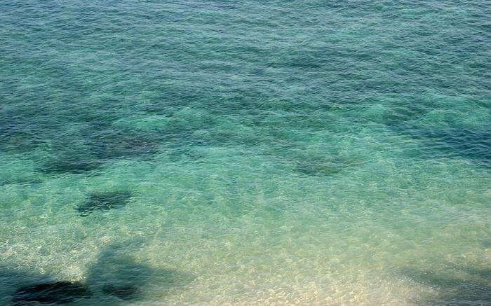 Clear turquoise ocean water with sandy bottom
