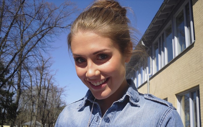 Young woman with hair in a bun wearing a denim shirt
