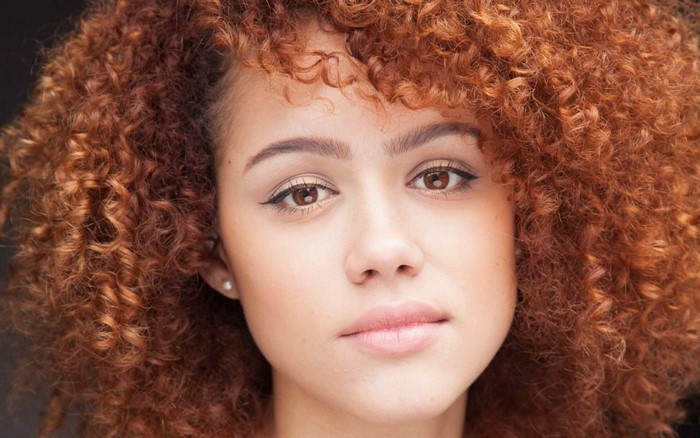 Nathalie Emmanuel with curly red hair close up portrait