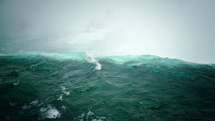Ocean wave under a cloudy sky