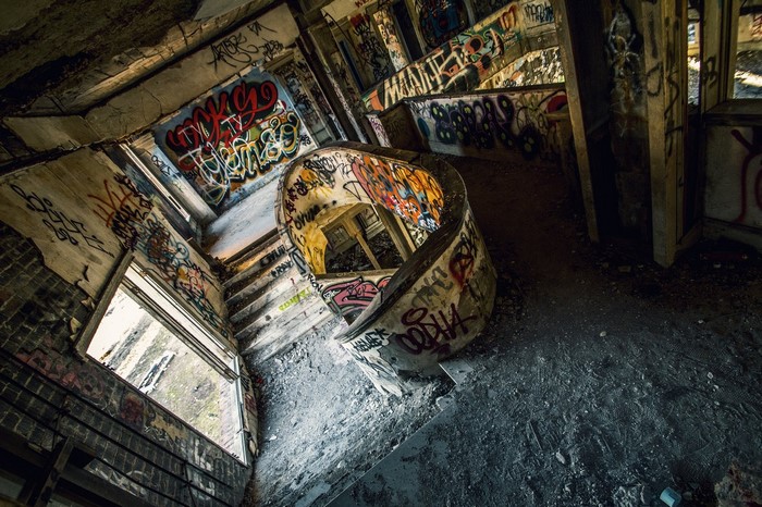 Graffiti-covered abandoned building with spiral staircase