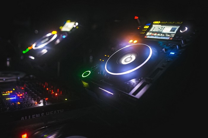 DJ turntables and mixer in a dark club