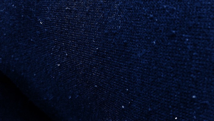 Close-up of dark blue fabric texture with small white specks