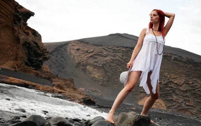 Redhead Woman in White Dress Posing on Rocky Beach