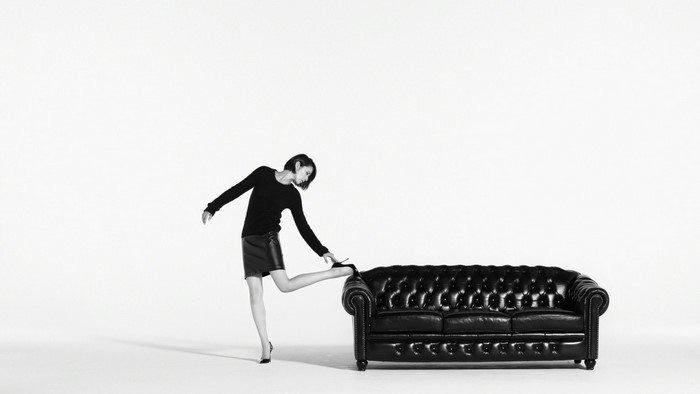 Masami Nagasawa on a black leather couch