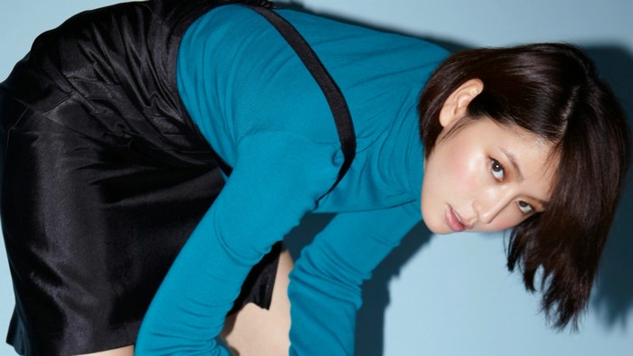 Model Masami Nagasawa wearing a blue turtleneck and black skirt