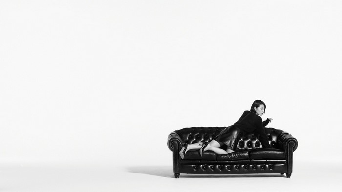 Masami Nagasawa on a black leather couch