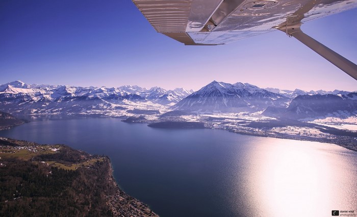 Aerial view of snow-capped Alps mountains and a lake