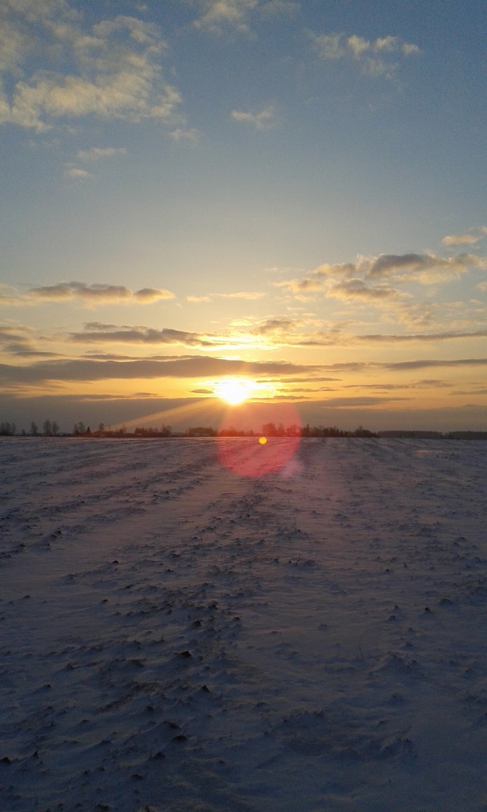 Sunset over a snow-covered field in Lithuania