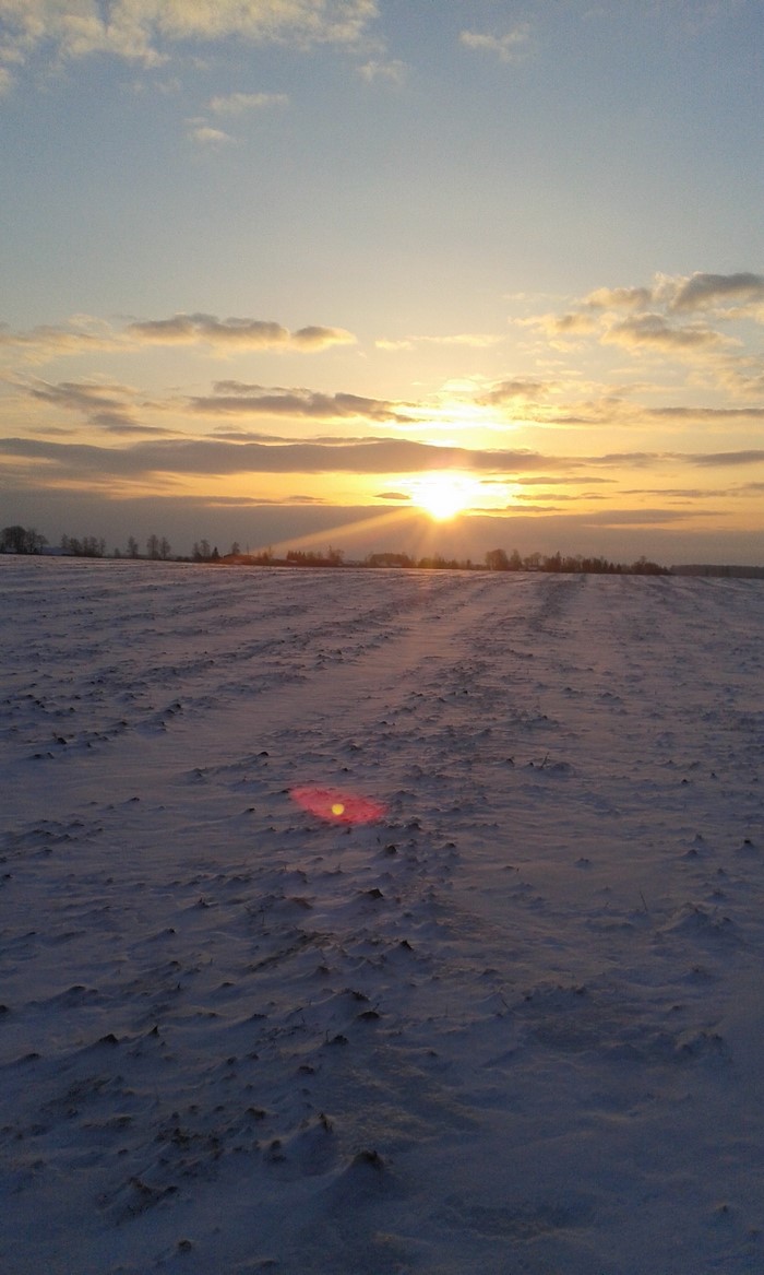Sunset over a snow-covered field in Lithuania