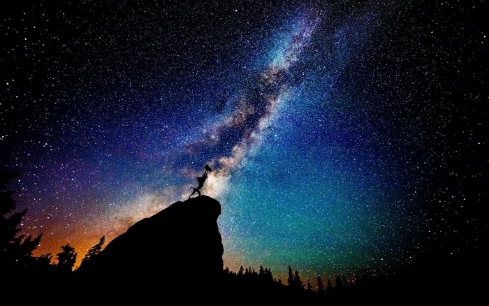 Silhouette on Cliff Under Milky Way Galaxy Night Sky