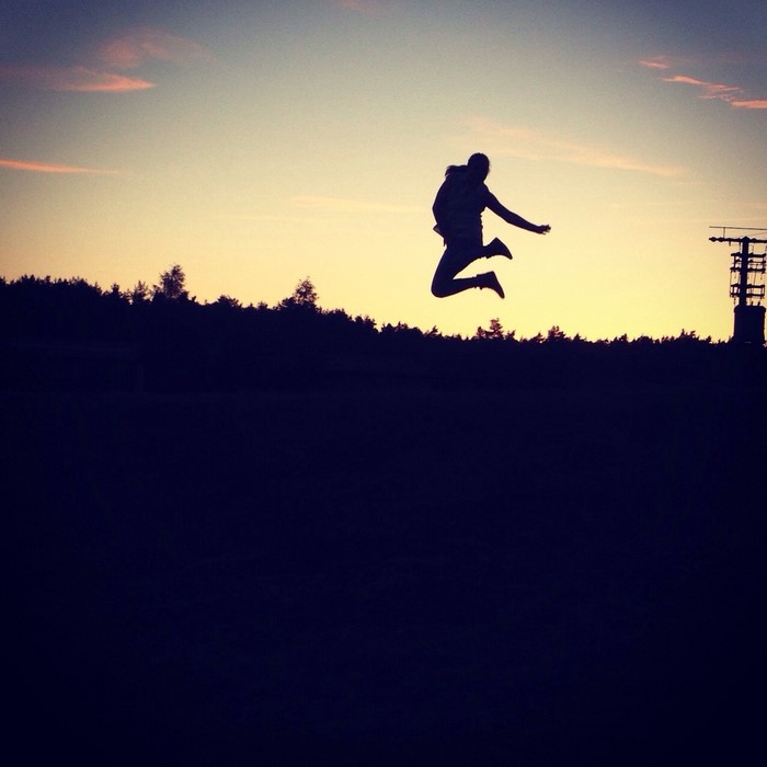 Silhouette of a person jumping at sunset