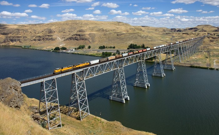 Freight Train Crossing Steel Bridge Over River