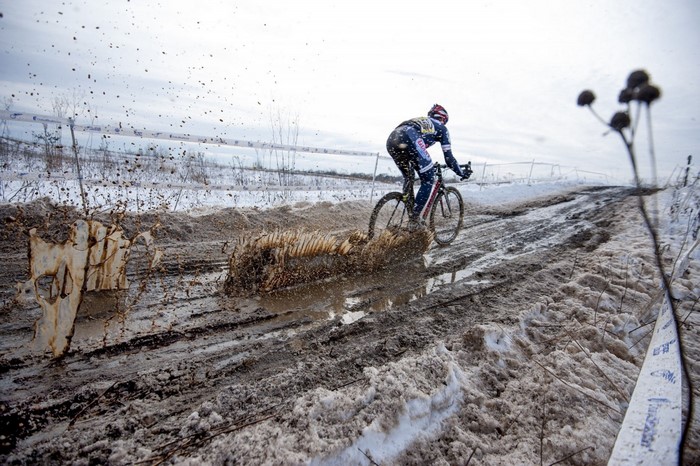 Cyclist riding through mud and snow during a race