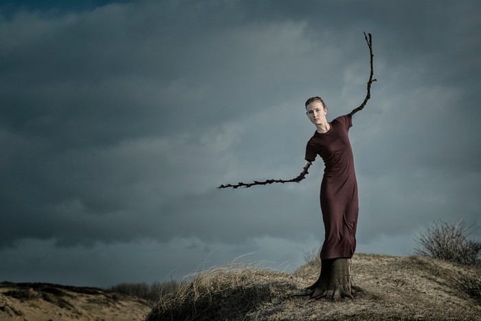 Woman with tree trunk body and branch arms