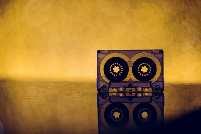 Cassette tape on a reflective surface with bokeh background