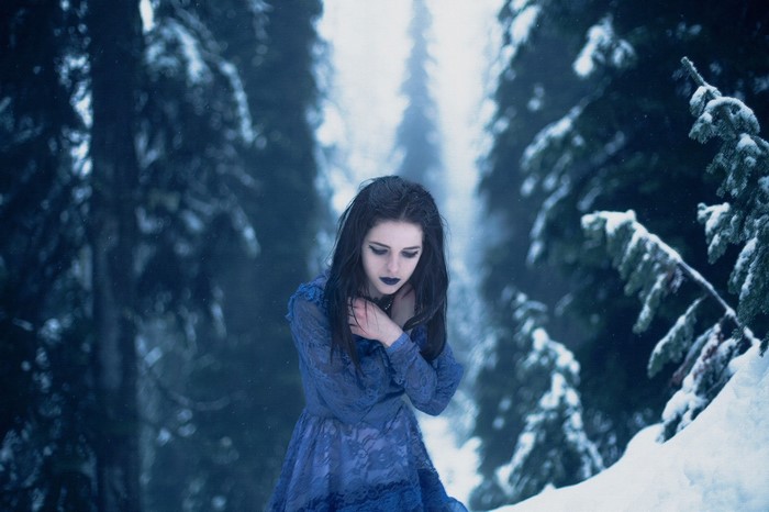 Woman in blue dress in snowy forest