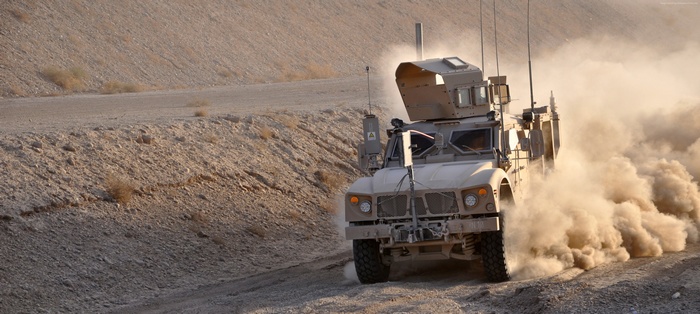 Oshkosh M-ATV driving through dust in a desert
