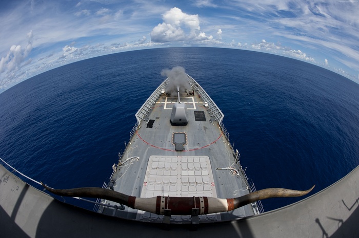 USS Cowpens (CG-63) fires its gun at sea