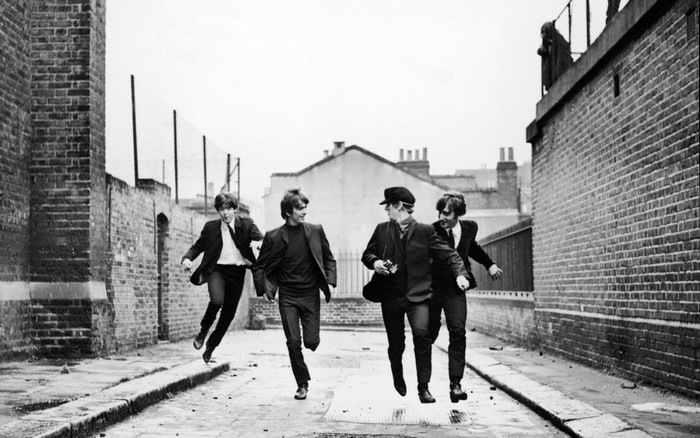 The Beatles running down a street