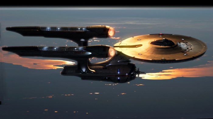 Star Trek Enterprise NCC-1701 flying over Earth at sunset