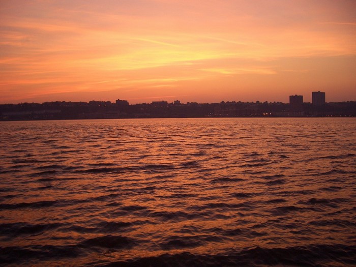 Sunset over water with city skyline