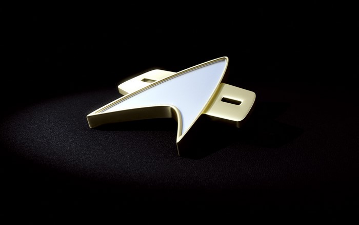 Star Trek communicator badge on black background