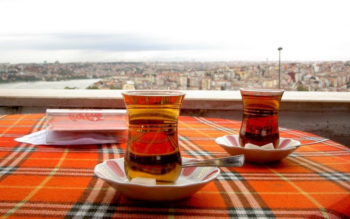 Two glasses of Turkish tea on a table overlooking a city