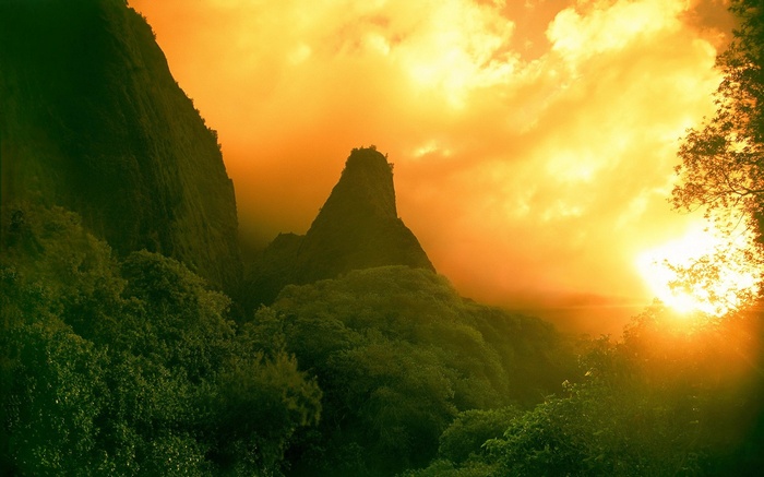 Mountain peak shrouded in mist at sunset
