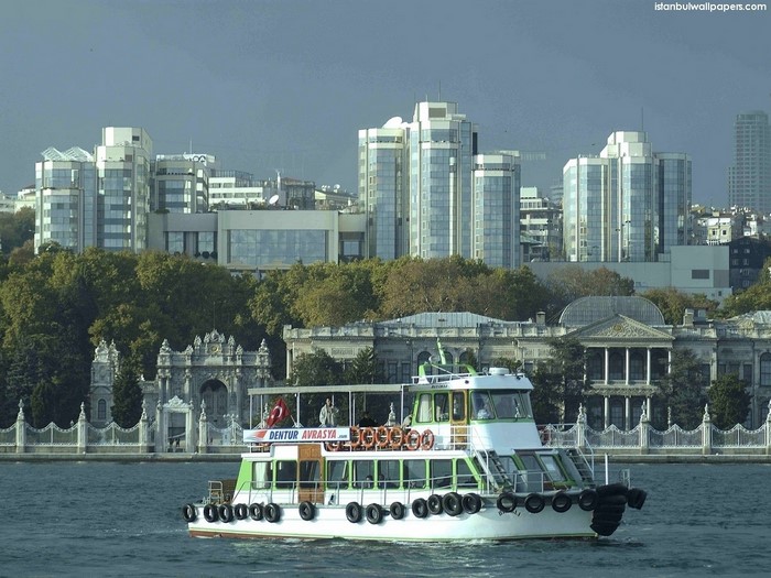 Ferry boat sailing in Istanbul waterway with modern buildings