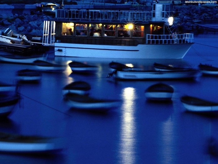 Boats docked at night in Istanbul with reflections
