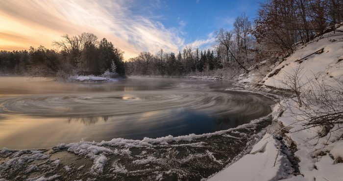 Winter river with ice and mist at sunrise
