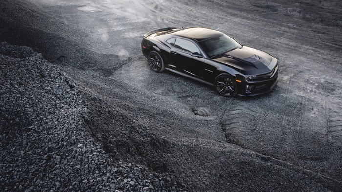 Black Chevrolet Camaro on a gravel surface