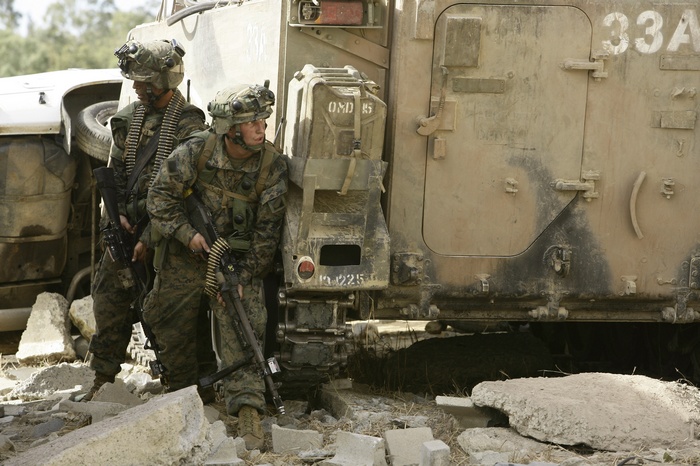 Marines with LMG and rifle near M113 vehicle
