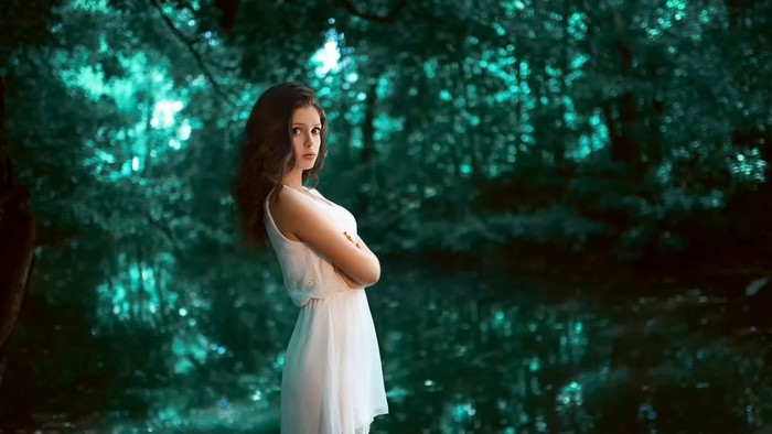 Woman in white dress in a dark forest