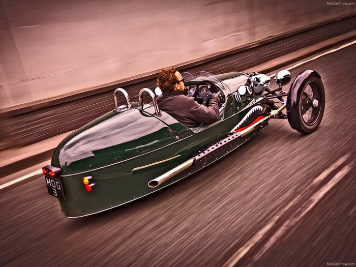 Green Morgan 3 Wheeler with Shark Mouth Decal Driving on Road