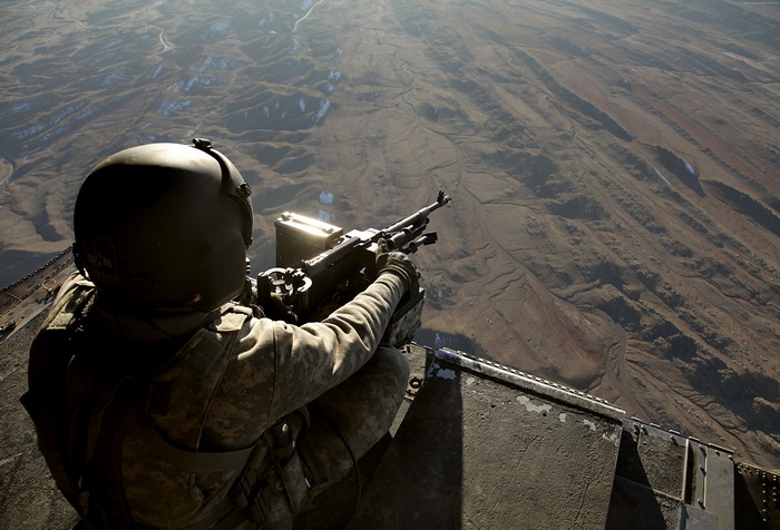 Soldier operating a machine gun from a CH-47 Chinook helicopter