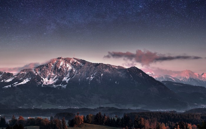 Snow-capped mountains under a starry night sky