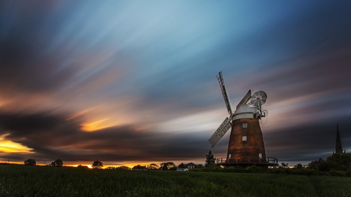 Windmill at sunset with long exposure clouds