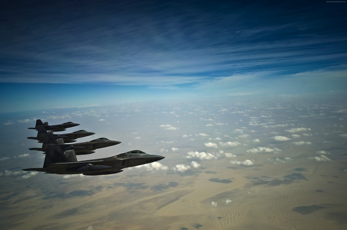 Four F-35A Lightning II jets flying in formation over clouds