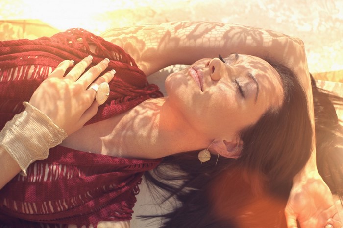 Woman lying down with red scarf and jewelry