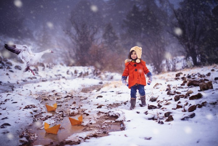 Girl and goose in a snowy landscape with paper boats