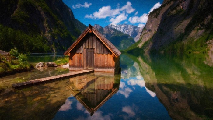 Wooden boathouse on a calm lake with mountains and reflections