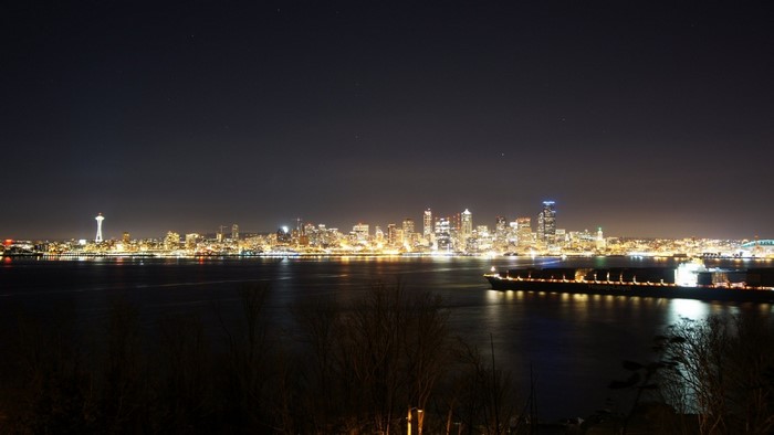 Seattle skyline at night with a cargo ship