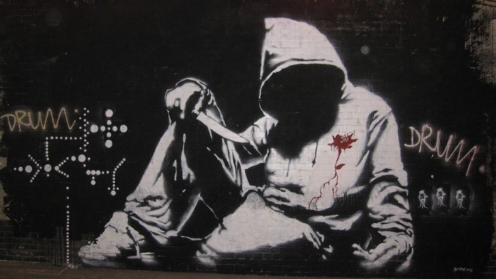Graffiti of a hooded figure with a knife and a rose