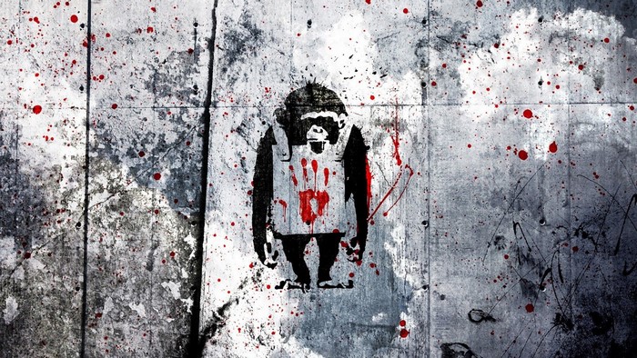 Graffiti of a monkey with a bloody handprint on a wall