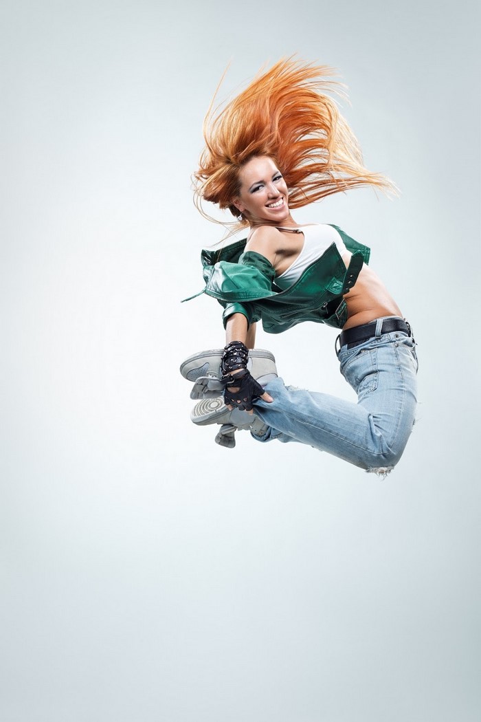 Woman in mid-air jump with red hair